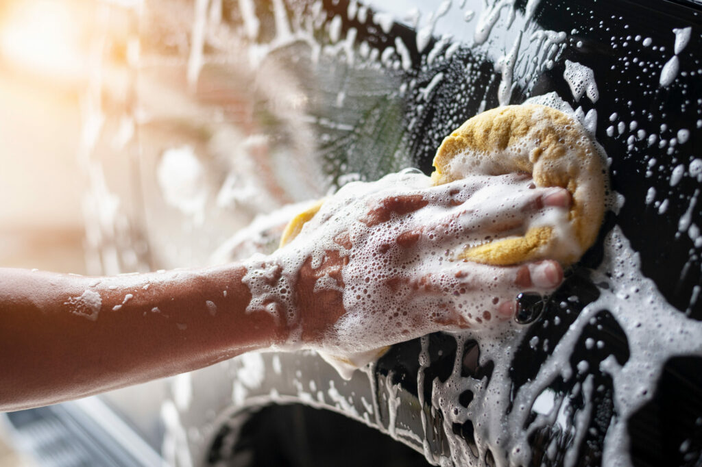 People cleaning car with sponge at car wash Autowelt Schuler